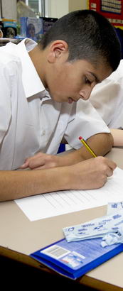 Four boys, heads down, taking
                  a test