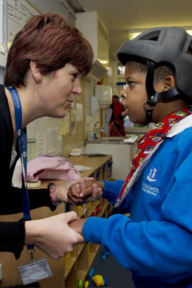 A female teacher interacts with a young
                  boy looking for clues in the learning process