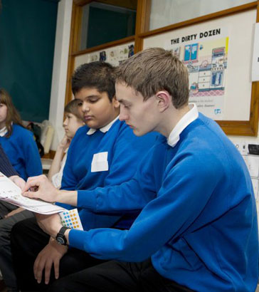 A girl smiles as a teacher sounds a manual
'bugle horn