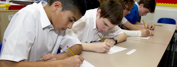 Boys writing during an English
                  lesson