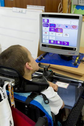 A teacher watches a boy use ICT
equipment