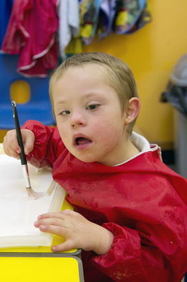 A boy holds a brush