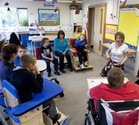 Children and adults sit in a semicircle