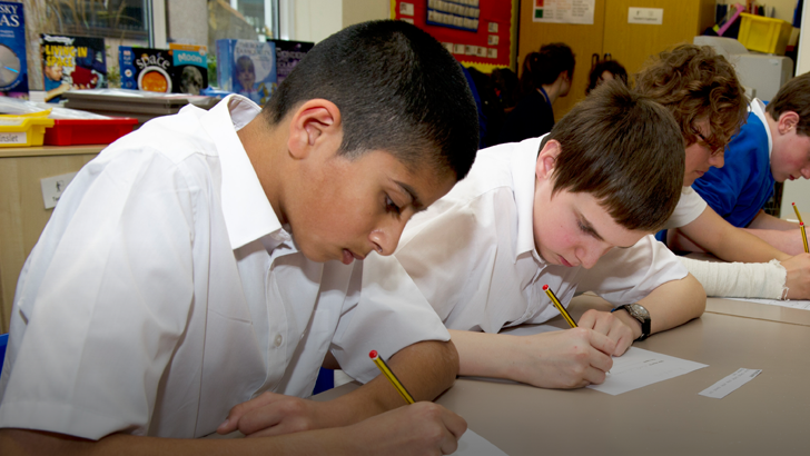 A row of boys writing at a
classroom table