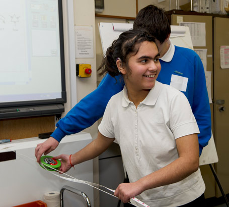 A girl with a measuring tape participates
                  in a science project