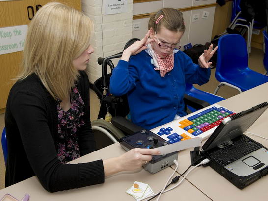 A girl and her teacher in front
                  of a keyboard during an English lesson