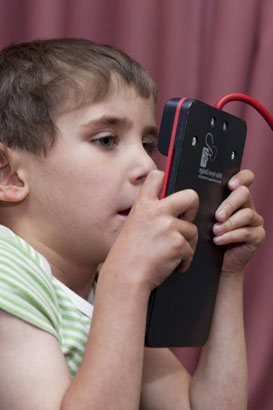 a young girl communicates using a tech
                  talk device