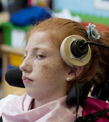 young boy in chair uses a head operated
                  switch