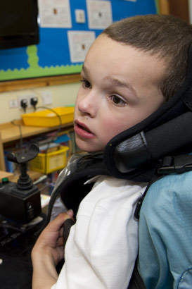 Young boy with supportive ICT
equipment sits in front of interactive computer screen