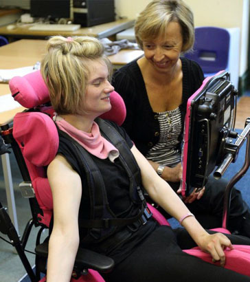 Teacher and young girl sit in front
                  of interactive ICT equipment