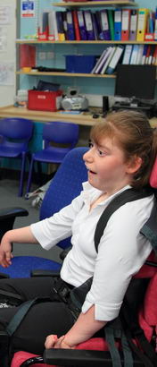 A teacher helps a young girl to communicate
                  using a screen at eye level