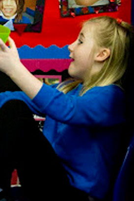 Close up of a girl watching  her
                  teacher using a puppet