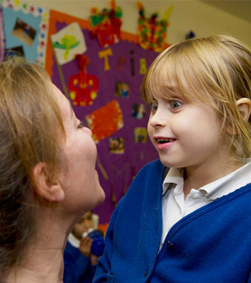 A teacher engages with a young girl