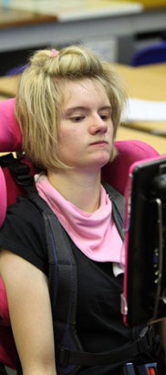 Girl in wheelchair at a computer with her
                  teacher