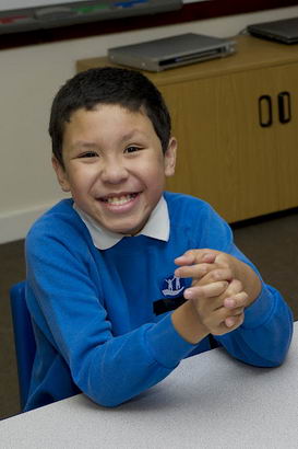 Young boy and female teacher fully
engaged at school desk