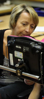 Teacher at a computer with a girl in a wheelchair