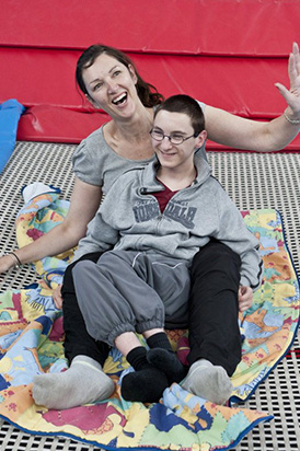 barefoot teacher with girl on chair