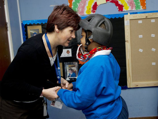 A teacher comforts a young boy who is
                  distressed