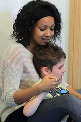 Carer holds distressed boy