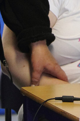 A carer holds a young girl's hand to calm
her