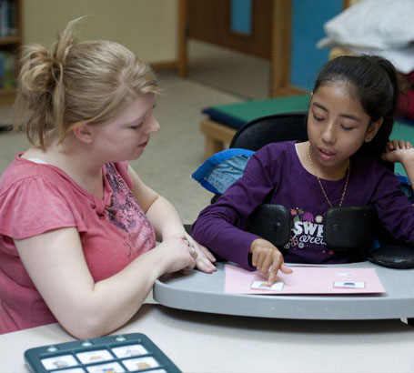 A girl chooses a card from her carer