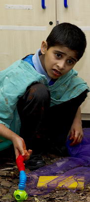 Young boy squatting in activity
area of classroom