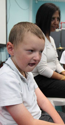 A female teacher comforts a distressed
young boy on her lap