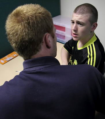 A teacher comforts and reasons with a
distressed teenage boy