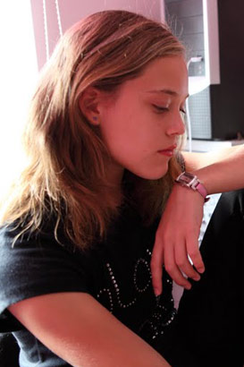 A teenage girl with downcast eyes