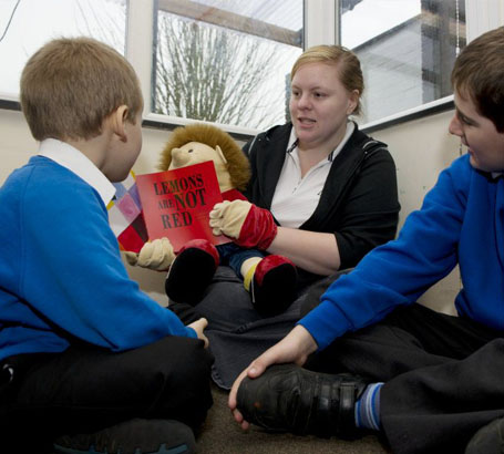 A young female teacher comforts an anxious
young boy