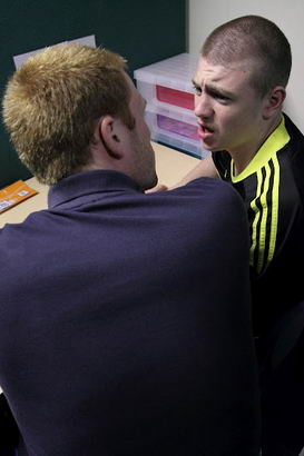 Young man at desk with teacher