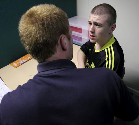 A teenage boy speaks with his teacher
                  during a diagnostic review