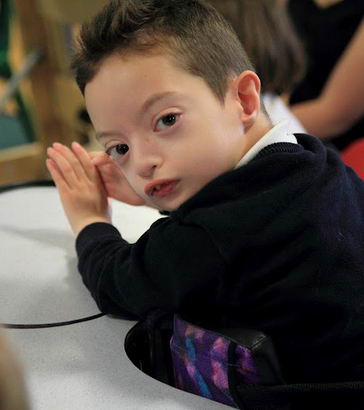 A boy in a standing support turns to the
camera
