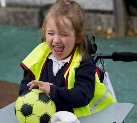 A girl laughing with a ball and a
                  telephone