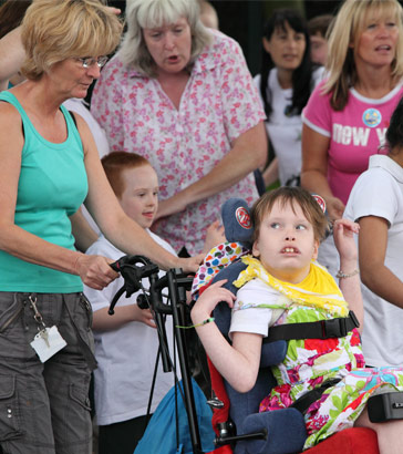 A girl in a wheelchair amongst a group of
children and adults