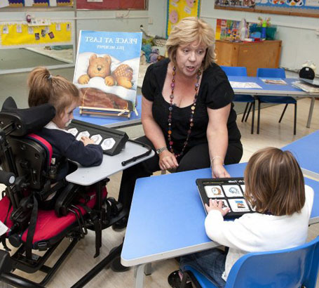 Using a puppet crocodile a teacher interacts
                  with a girl