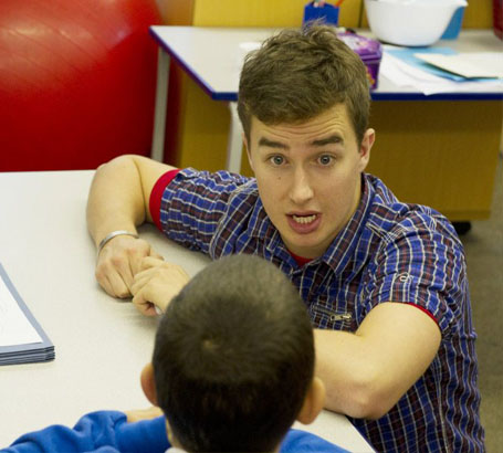 Two teachers interacting with a child
                  using a toy