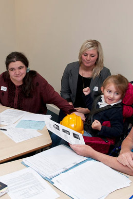 A disabled girl in a meeting alongside
teachers and professionals