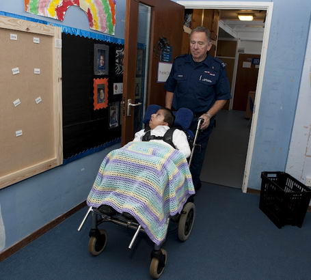 A boy covered in a blanket is
wheeled along a corridor