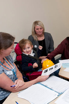 A disabled girl in a meeting alongside
                  teachers and professionals