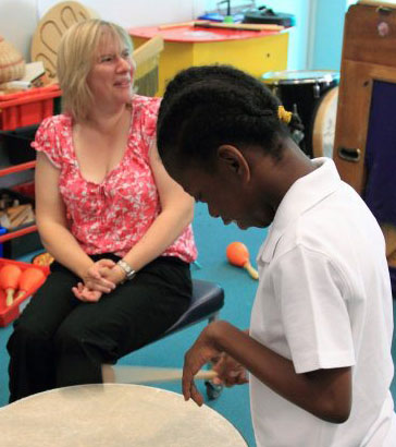 Teacher helping a boy understand an activity
card