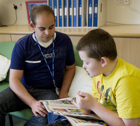 Teacher with child reading a card.