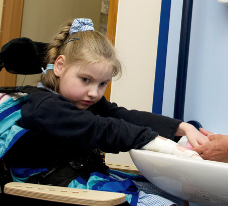 A teacher helps a girl wash her
hands