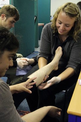 A physiotherapist works on a girl's leg