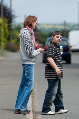 Two young adults cross a road