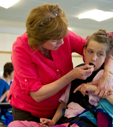 A girl being fed by her teacher