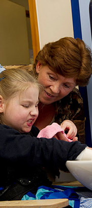 A teacher helps a girl wash her
                  hands