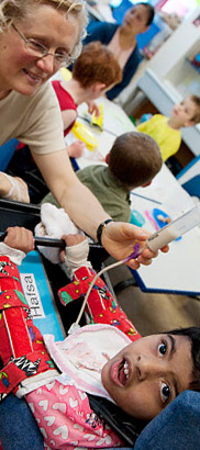 A teacher holds a child's feeding
                  tube