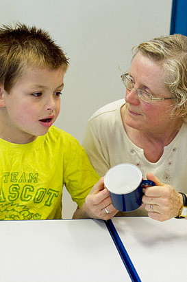 A boy and his teacher with a cup