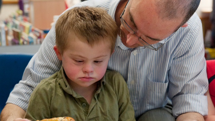 A teacher sits behind a boy
helping him with his food selection